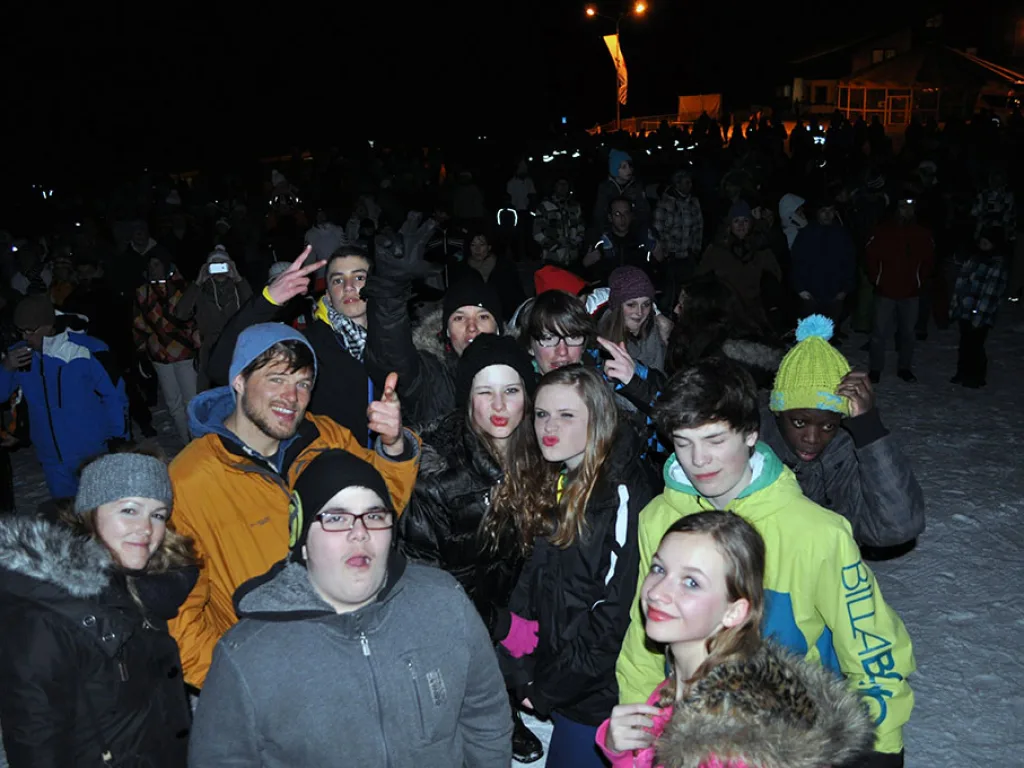 Jugendliche stehen abends im Freien und posieren für ein Foto.